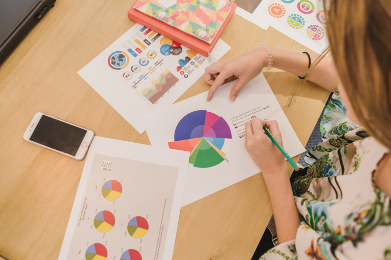 E-commerce & Online Business Design | Studia I stopnia we Wrocławiu | Uniwersytet WSB Merito we Wrocławiu: Kobieta analizuje dane na wykresie z ołówkiem w dłoni