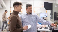 Inżynieria systemów i technologii cyfrowych w logistyce | Studia I stopnia we Wrocławiu | Uniwersytet WSB Merito we Wrocławiu: student i wykładowca podczas zajęć w pracowni inżynierskiej