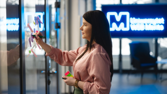 Professional Management dla początkujących | Studia podyplomowe we Wrocławiu | Uniwersytet WSB Merito we Wrocławiu: uczestniczka studiów podyplomowych przyklejająca fiszki do szyby