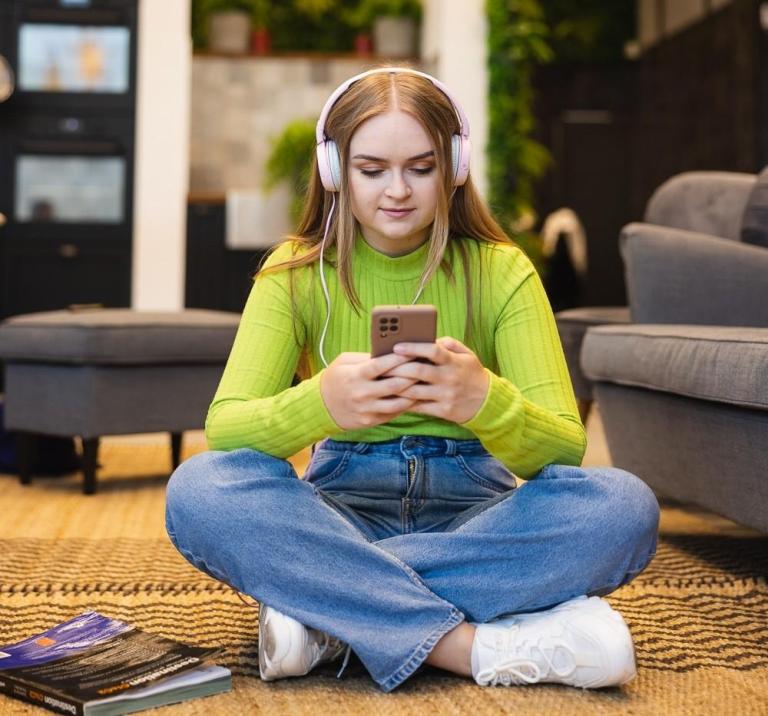 Cyfrowy uniwersytet | Uniwersytet WSB Merito we Wrocławiu: studentka - słuchawki - telefon