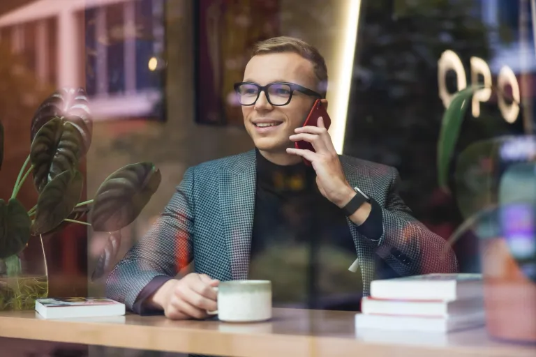Służby i bezpieczeństwo publiczne | Studia II stopnia we Wrocławiu | Uniwersytet WSB Merito we Wrocławiu: student w kawiarni rozmawiający przez telefon