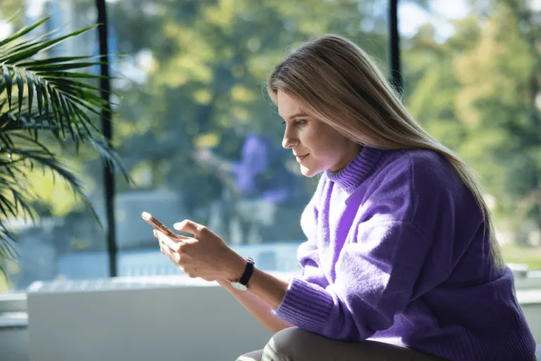 Webinar dla studentów: Czy aplikacja może manipulować? | Aktualności | Uniwersytet WSB Merito we Wrocławiu: Dziewczyna patrząca na smartfon